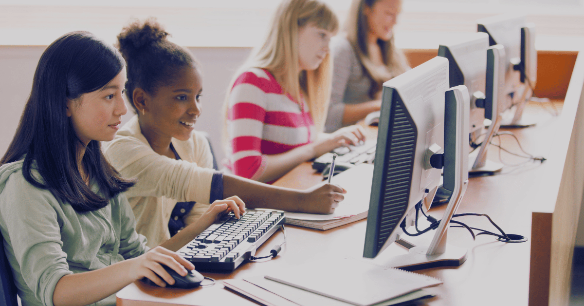 a group of students working on computers in a classroom